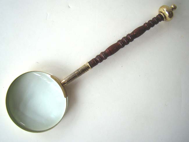 An antique English Magnifying Glass with carved wooden handle and brass mounts